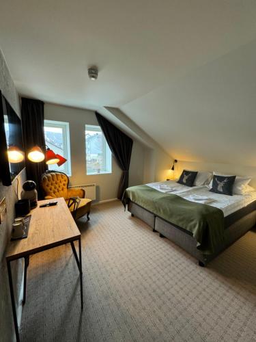 霍宁斯沃格Arctic Hotel Nordkapp的一间卧室配有一张大床和一张桌子