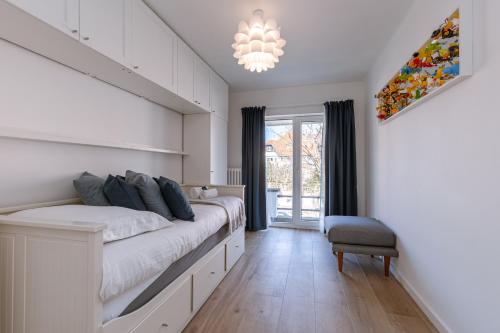 克诺克－海斯特Pins Dorés - A Luxurious and beautifully decorated villa with terrace and parking near the beach的一间卧室配有一张大床和一个吊灯。