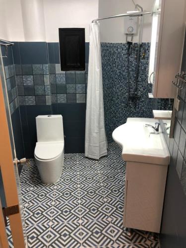 巴迪安Cuestas Beach Resort and Restaurant的浴室配有卫生间、盥洗盆和淋浴。