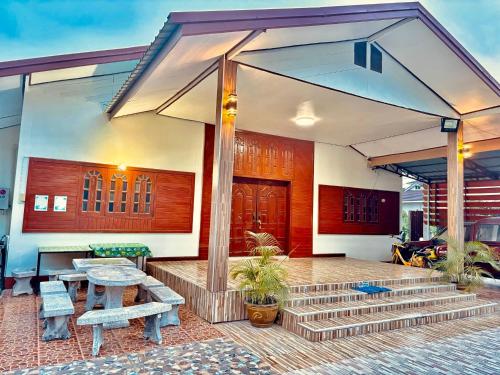 清刊บ้านคุณโต้ง เชียงคาน BaanKhunTong ChiangKhan的房屋设有带桌子和长凳的庭院