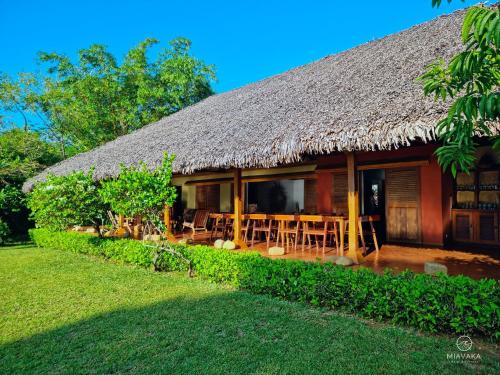 AmbatobeMiavaka Lodge的茅草屋顶和庭院的房子