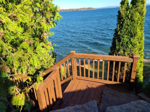 普拉茨堡Loza house adirondack screened-in porch unit lake front的木凳,坐在水体旁边