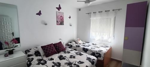 莫莱拉Casa Marina的卧室配有两张床,墙上挂着蝴蝶。