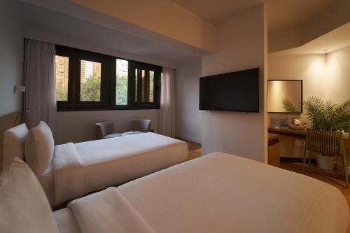 开罗New President Hotel Cairo的酒店客房设有两张床和一台平面电视。