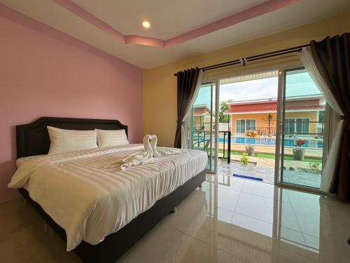 普吉镇พัชรี รีสอร์ท ภูเก็ต Patcharee Resort Phuket的一间卧室配有一张床,享有游泳池的景色
