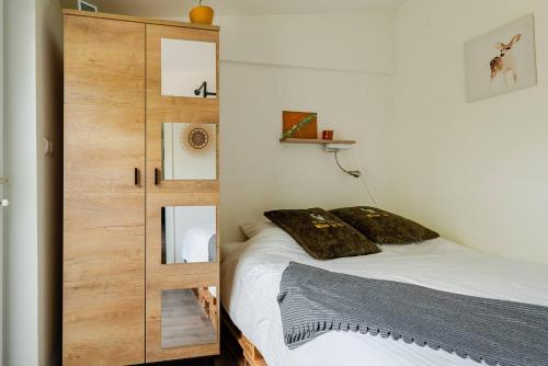 奈梅亨Tiny house - fietsverhuur, eigen keuken en badkamer的一间卧室配有一张床和一个木制橱柜