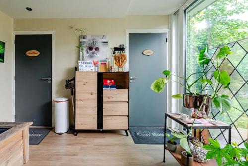 奈梅亨Tiny house - fietsverhuur, eigen keuken en badkamer的一间设有梳妆台和大窗户的客房