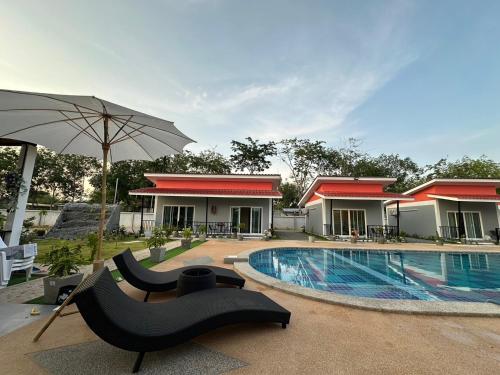 普吉镇พัชรี รีสอร์ท ภูเก็ต Patcharee Resort Phuket的一个带游泳池和遮阳伞的度假胜地