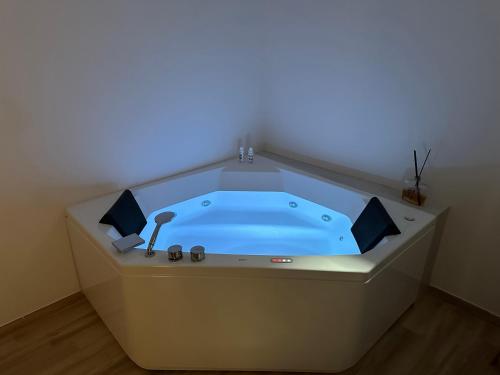 拉奎拉Maison Costa Masciarelli的客房内的按摩浴缸拥有蓝色的灯光