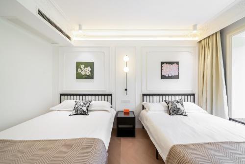 上海Shanghai YD B&B - Yu Garden Bund Store, 400m near Yu Garden subway的配有2张床的白色墙壁和窗户客房