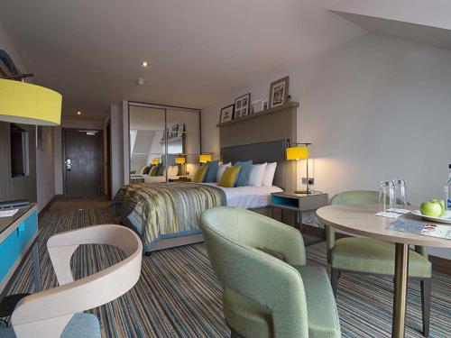 锡米尔The Waterside Hotel的酒店客房带一张床、一张桌子和椅子