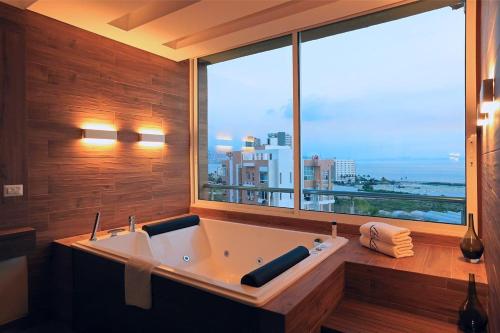 朱尼耶Ibiza Hotel的带浴缸和大窗户的大浴室