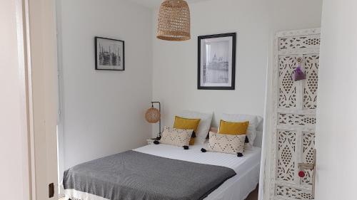 土伦Le Doux voyage T3, vue Mer, Wi Fi, PARKING gratuit的一间小卧室,配有一张带黄色枕头的床