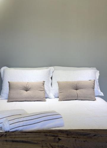 新文达移民镇Chalés Peterli 2的一张白色的床,上面有两个枕头