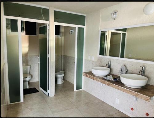 阿卡普尔科Casa con vista espectacular al mar con alberca的浴室设有2个水槽和2个卫生间