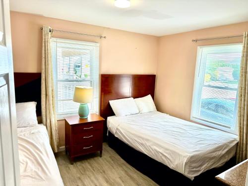大洋城Bill's Apartments的一间小卧室,配有两张床和两个窗户