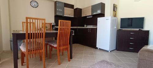 金沙Europroperties Bendita Mare Apartments的厨房配有桌椅和冰箱。