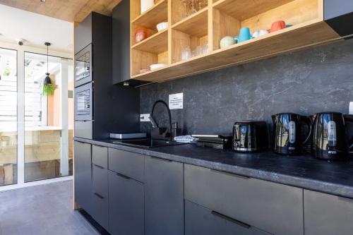 杜布罗夫尼克佩特拉海滨旅舍的厨房配有黑色台面和木制橱柜