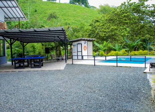 金巴亚FINCA CAMPESTRE EL PORVENIR的一个带野餐桌和游泳池的庭院