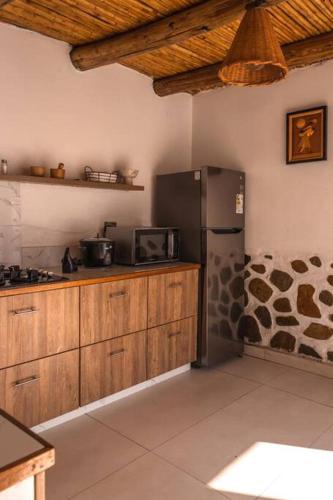 特鲁希略Infinity House的厨房配有黑色冰箱和木制橱柜。
