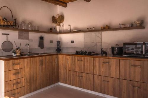 特鲁希略Infinity House的一间带木制橱柜和微波炉的厨房