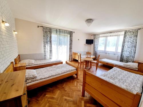 弗罗茨瓦夫Hostel Rumiankowy Airport Hostel的带四张床和窗户的客房