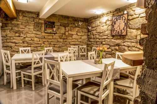 维斯瓦Pokoje u Marioli的一间带桌椅和石墙的餐厅