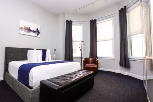 波士顿Large Stylish Newbury Street Studio w/ Kitchen的配有一张床和一把椅子的酒店客房
