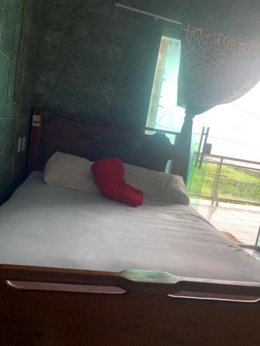 Pousada e Restaurante na Orla de Colares的床上有红色枕头