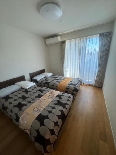 大阪Residence Saku的一间卧室,配有两张床