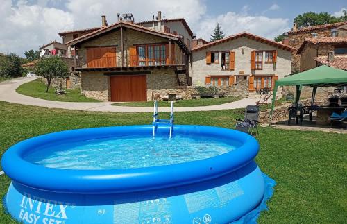 坎姆帕拉斯Can Tubau - Casa rural - Apartaments的房屋的院子内的热水浴池