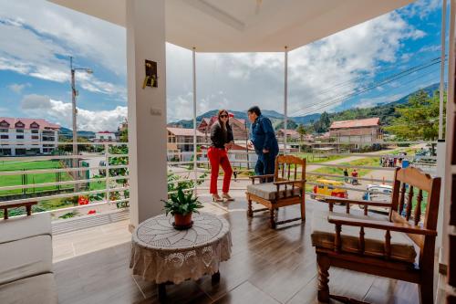 奥克萨潘帕Las Yungas Hospedaje的两个人站在一个窗外的阳台上