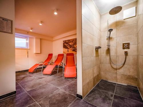 平茨高谷地瓦尔德Lodge Elise的一间配备有橙色椅子和淋浴的等候室