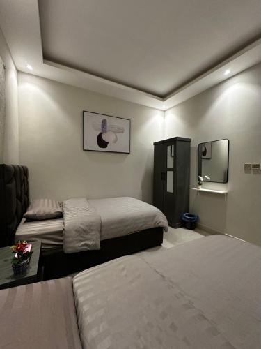 阿可贺巴هابي رومز的酒店客房,设有两张床和镜子