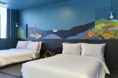 首尔卡布奇诺酒店的墙上画画的房间里设有两张床