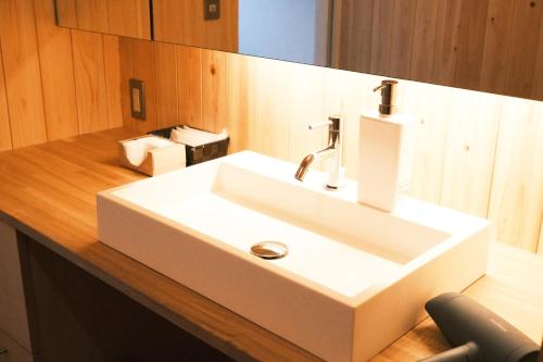 白马村古民家ホテル 結 YUWAI的木制柜台上带白色水槽的浴室