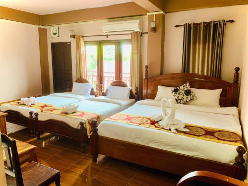 万荣Happy Riverview Hotel的一间卧室设有两张床和窗户。