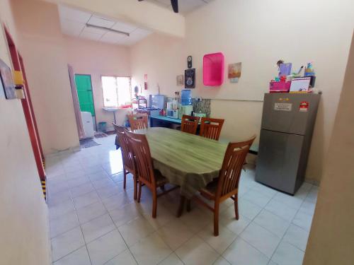 巴力拉惹Homestay Melewar的厨房配有桌椅和冰箱。
