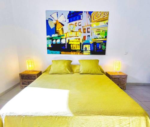 VaïareShared Pool King Bed & Air-Conditioned Cozy Apartment的卧室配有一张黄色的床,墙上挂着一幅画