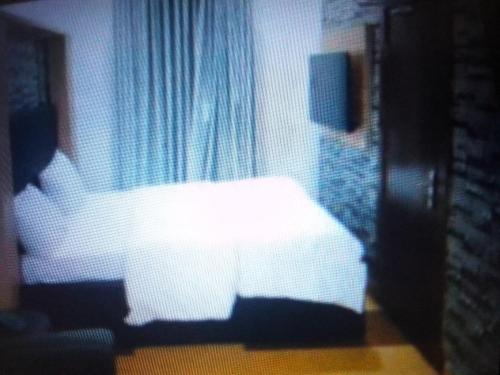 IladoExclusive mansion hotel and suites Lagos的卧室在窗户前配有白色床
