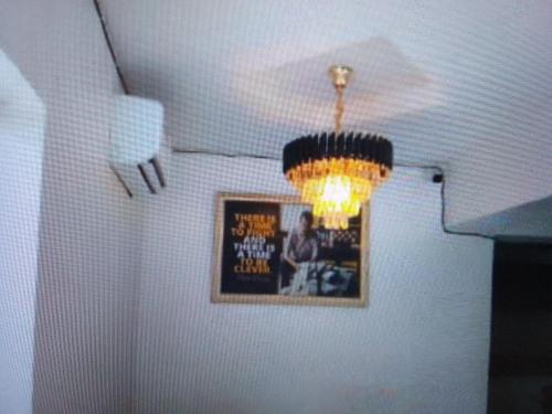 IladoExclusive mansion hotel and suites Lagos的墙上挂着照片的房间的吊灯