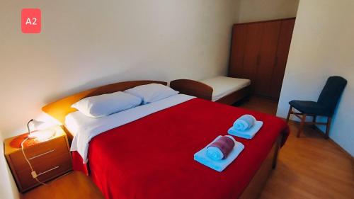 韦利拉特Apartments Josef - sea view的一间卧室配有红色的床和2条毛巾
