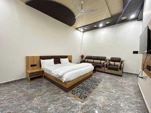 FaizābādOYO Flagship Hotel Pranav Inn的一间卧室配有一张床和一张沙发