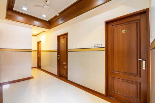 班加罗尔OYO Hotel Sunil Residency的房屋内空空的走廊,有木门
