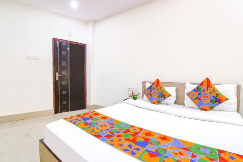 加尔各答FabExpress Vhyom Sky Palace的一间卧室配有两张带色彩缤纷枕头的床