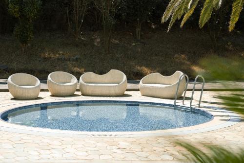 西归浦市Phoenix Island的一个带三把椅子和一张桌子的游泳池