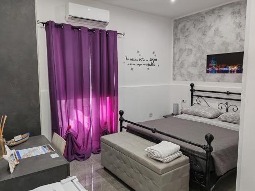 布林迪西Le Sirene的一间卧室配有一张紫色窗帘的床