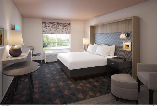 休斯顿Holiday Inn & Suites Houston NW - Willowbrook, an IHG Hotel的配有一张床和一张书桌的酒店客房