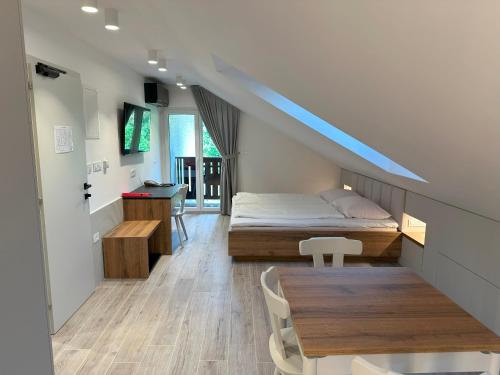 洛加泰茨Žigon Bed & Breakfast的一间卧室配有一张床和一张木桌