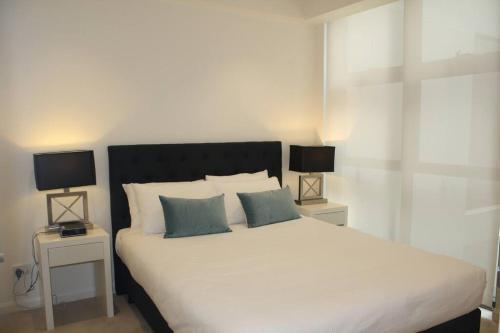 悉尼Perfect large one bedroom plus study - ALB09518的一间卧室配有一张带两盏灯的大型白色床。